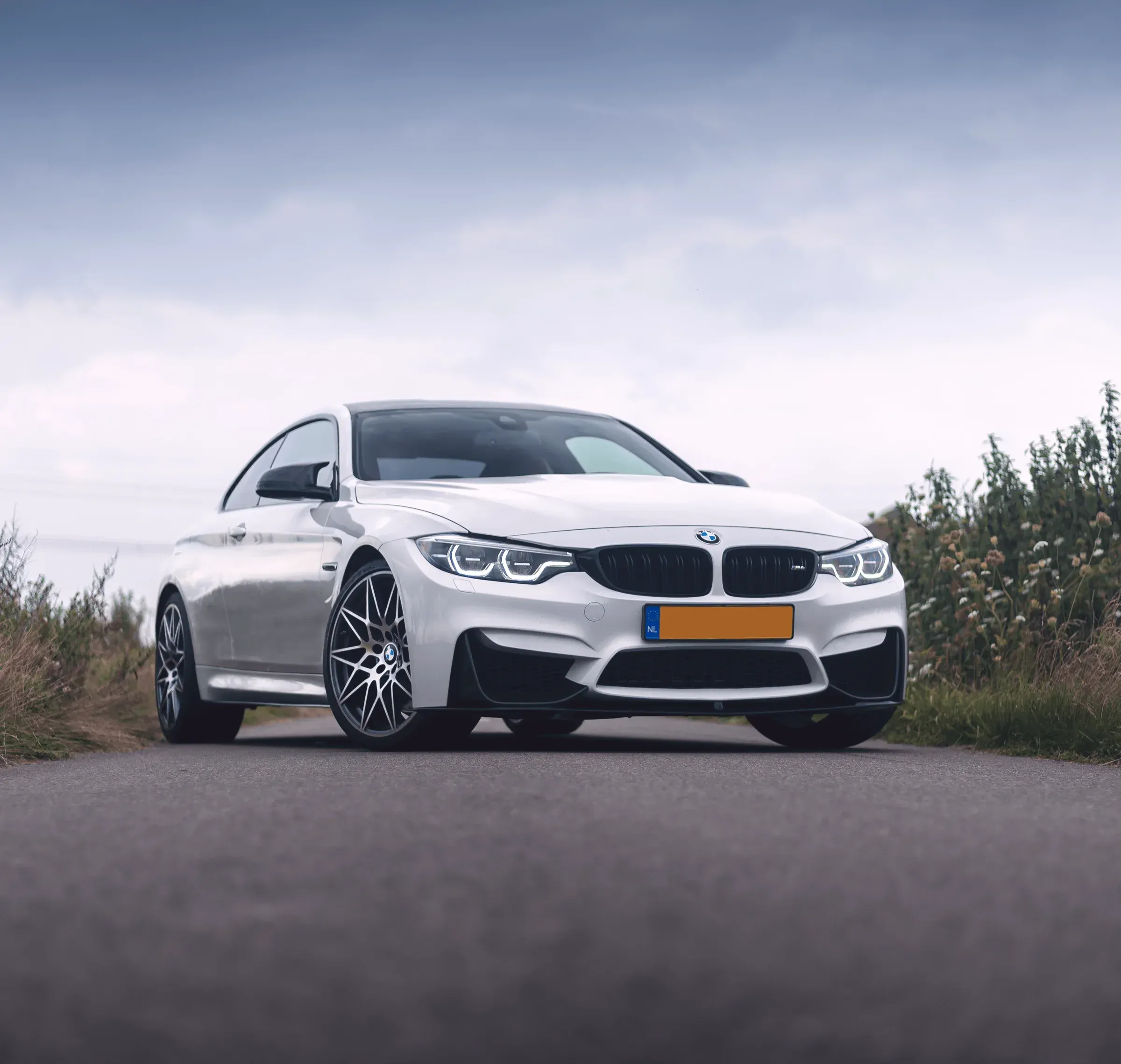 White BMW M4 in square crop with a warmer colour profile, centred as a sculptural automotive portrait