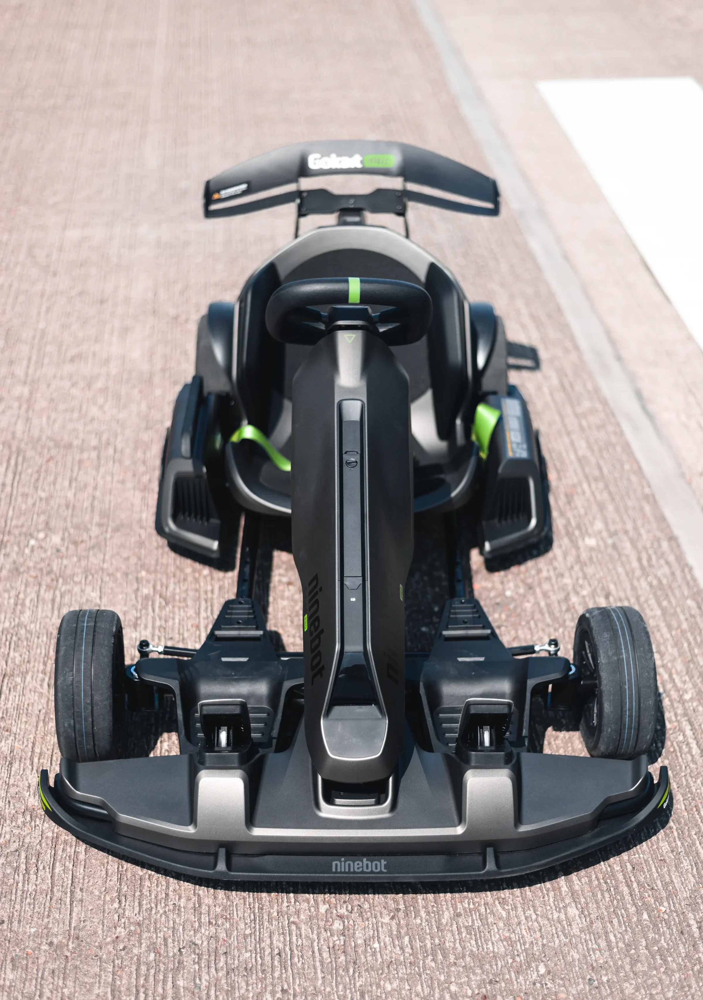 Vertical portrait of a go-kart driver in helmet and race suit, stillness before speed